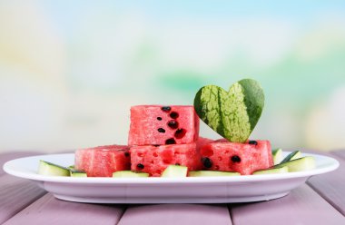 ahşap masa doğal zemin üzerinde beyaz tabakta karpuz dilimleri