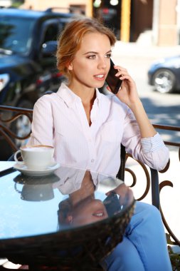 Güzel genç bayan kafede oturuyor.