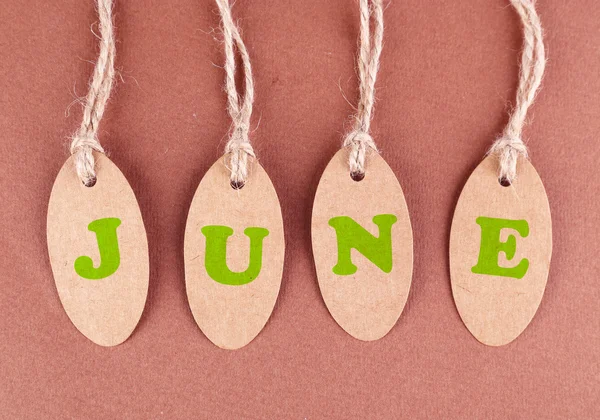 June tags on brown background — Stock Photo, Image