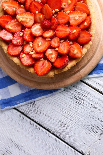 Erdbeertorte auf Holztablett, auf farbigem Holzhintergrund — Stockfoto