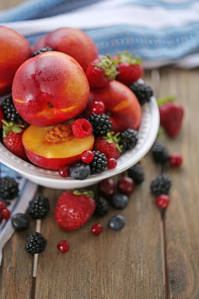 Peaches and berries in bowl — Stock Photo, Image