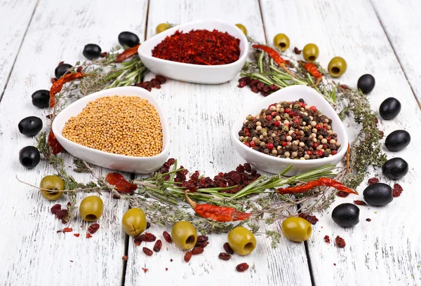 Spices in glass round bowls with herbs and chilly pepper on wooden background — Stock Photo, Image