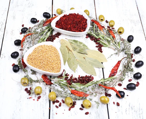 Spezie in ciotole rotonde di vetro con erbe aromatiche e peperoncino su fondo di legno — Foto Stock