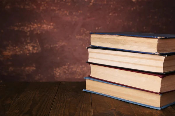 Livres sur table en bois sur fond sombre — Photo