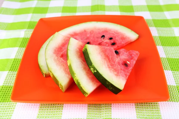 Watermelon on orange plate on  green tablecloth — Stock Photo, Image