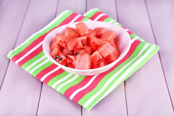 Wassermelonenscheiben in rosa Teller auf Serviette auf Holzgrund — Stockfoto