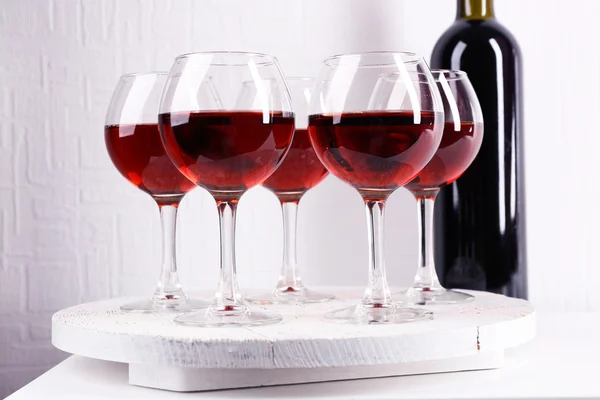 Gläser und Weinflasche auf Tablett im Zimmer — Stockfoto