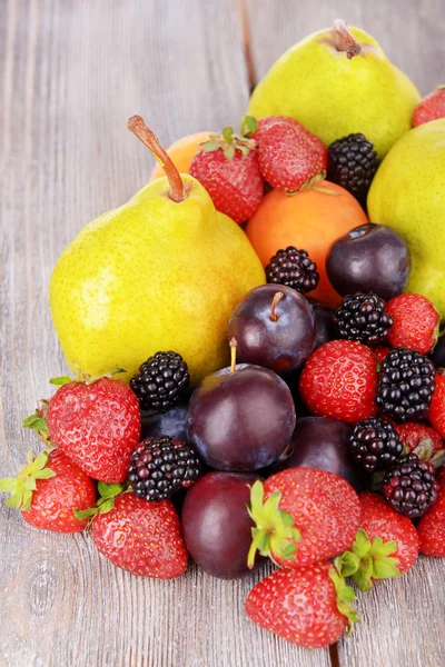 Ripe fruits and berries on wooden background — Stock Photo, Image