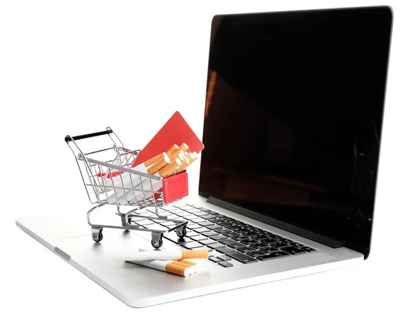 Shopping cart with cigarettes on laptop isolated on white — Stock Photo, Image