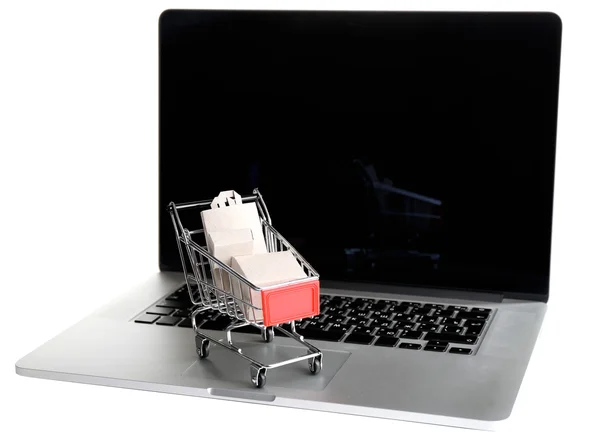 Shopping bags and boxes in shopping cart on laptop isolated on white — Stock Photo, Image