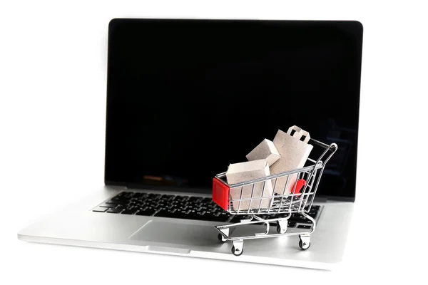 Bolsas y cajas de compras en el carrito de la compra en el ordenador portátil aislado en blanco —  Fotos de Stock