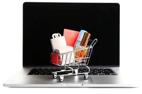 Parfüm şişeleri, poşetler ve kredi kartı laptop üzerinde beyaz izole alışveriş arabası — Stok fotoğraf