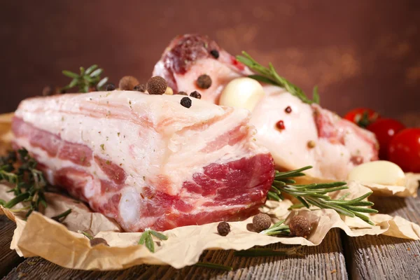 Nyers húsos szalonna, fűszereket és a paradicsomot, a fából készült asztal — Stock Fotó