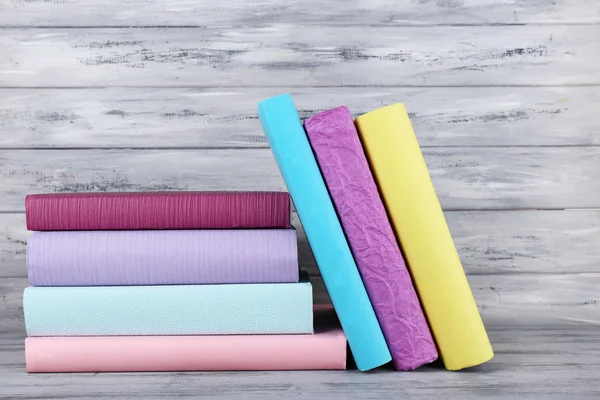 Libri a colori su sfondo grigio in legno — Foto Stock