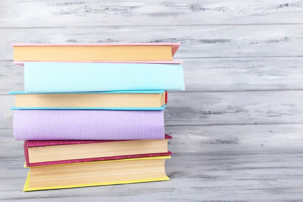Gri ahşap arka plan üzerinde renkli kitaplar — Stok fotoğraf