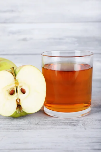 Glass of apple juice and fresh apples on grey wooden table — Stock Photo, Image