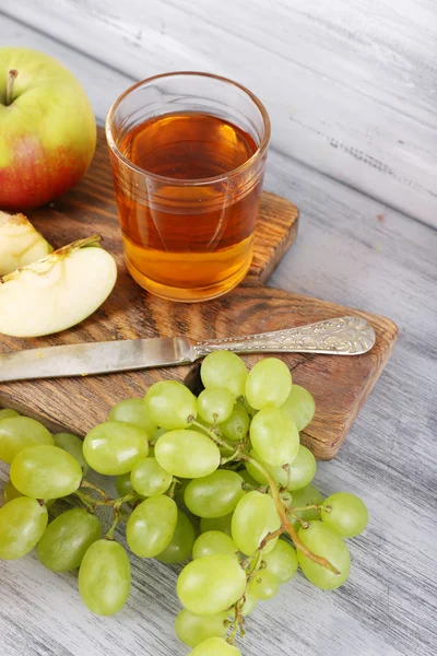 Стаканы сока со свежими фруктами на сером деревянном столе — стоковое фото