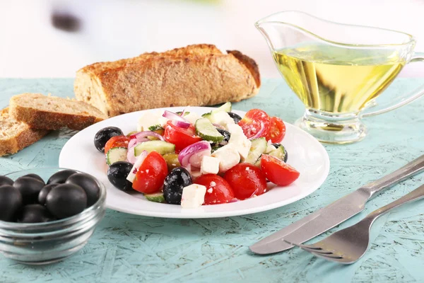 Ensalada griega en plato y pan sobre mesa de madera sobre fondo natural —  Fotos de Stock