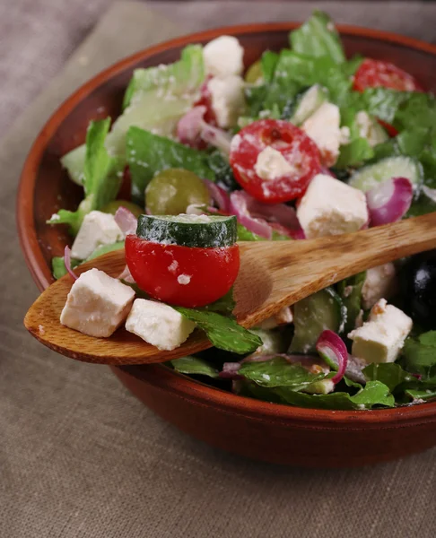 Bowl of Greek salad served on napkin on wooden background closeup — Stock Photo, Image