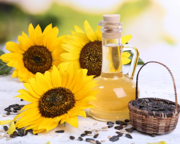 Sunflowers with seeds and oil on table close-up — Stock Photo, Image