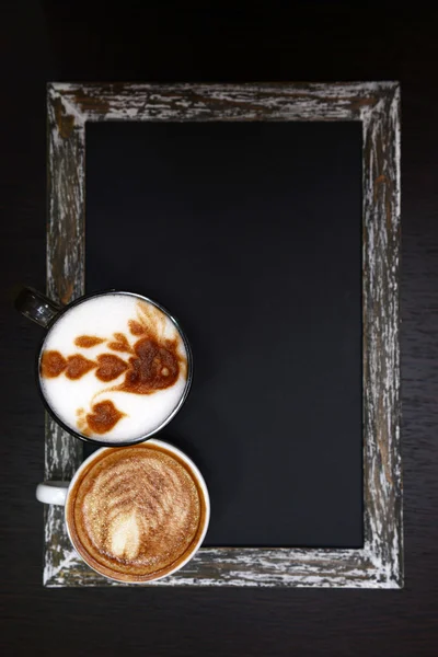 Cups of coffee with cute drawing in cafe — Stock Photo, Image