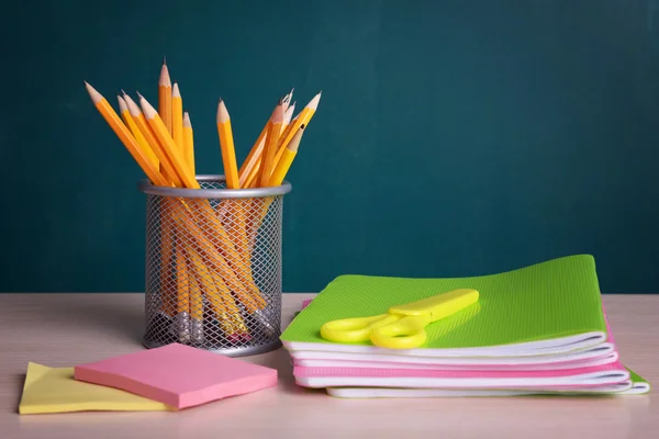 Schoolbenodigdheden op tafel aan boord van de achtergrond — Stockfoto