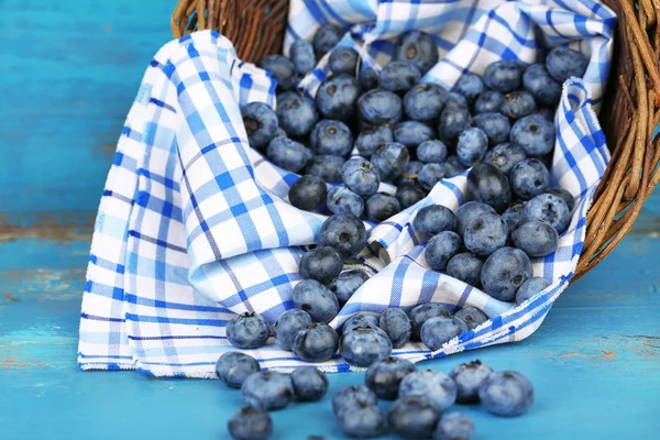Bleuets mûrs savoureux dans le panier, sur une table en bois — Photo