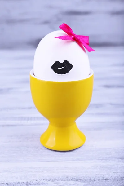 Яйцо в яичной чашке на сером деревянном фоне — стоковое фото