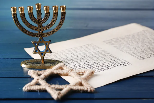 Menorah, star of David and page of Genesis book on wooden background — Stock Photo, Image