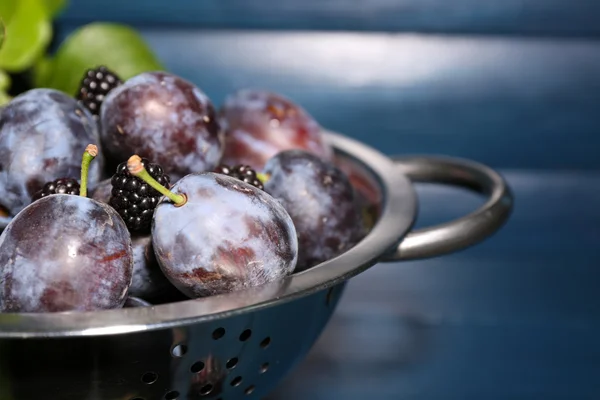 Prugne dolci mature in colino di metallo, su tavolo di legno — Foto Stock