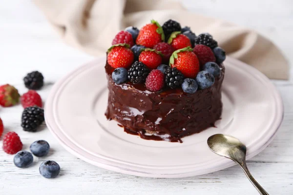 Tasty chocolate cake with different berries, on wooden table — Stock Photo, Image