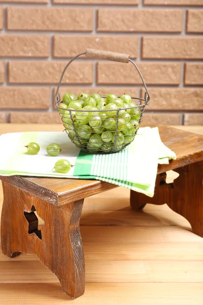 Frische Stachelbeeren im Korb auf Wandhintergrund — Stockfoto