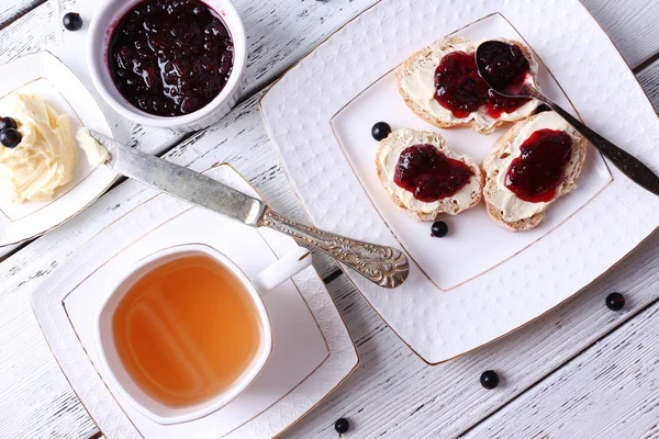 Fresh toasts with homemade butter and blackcurrant jam on wooden background — Stock Photo, Image