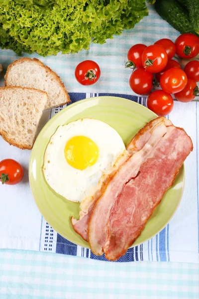 Uova strapazzate con pancetta e verdure servite sul piatto su fondo tessuto — Foto Stock