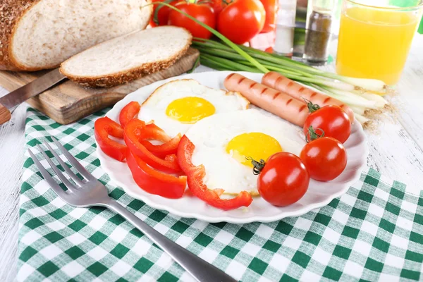 Œufs brouillés avec saucisse et légumes servis dans une assiette sur une serviette — Photo