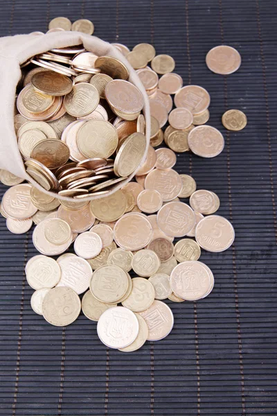 Fabric bag full of Ukrainian coins on wooden background — Stock Photo, Image