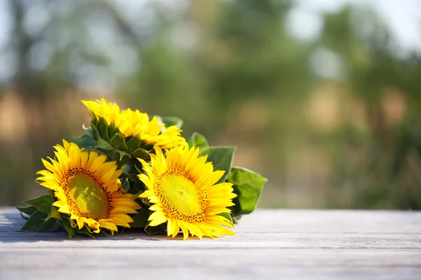 Beaux tournesols sur table sur fond lumineux — Photo