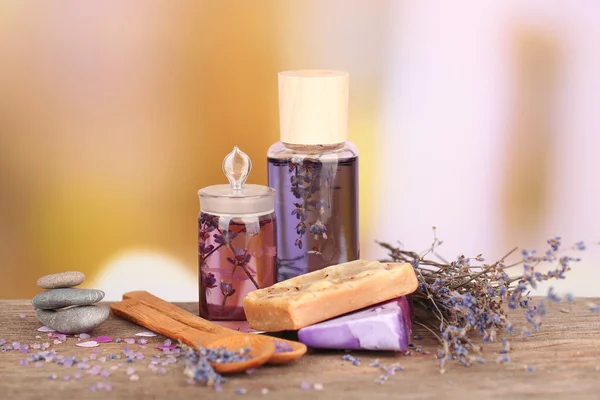 Lázně Zátiší s levandulovým olejem a květiny na dřevěný stůl, na světlé pozadí — Stock fotografie
