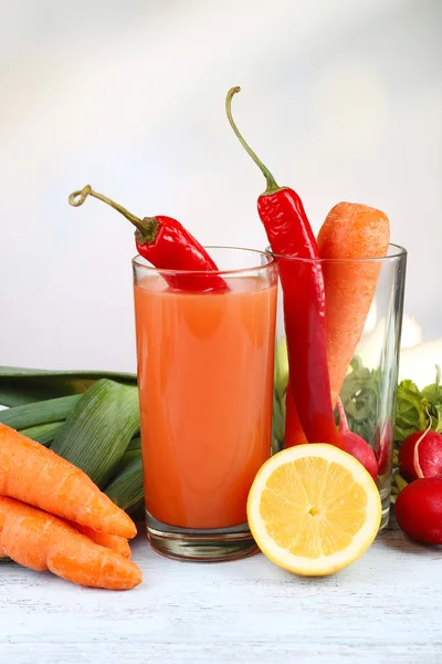 Glas färsk morotsjuice med grönsaker på träbord — Stockfoto