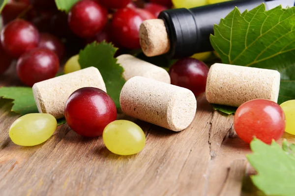 Wine bottle corks with grapes on table close-up — Stock Photo, Image