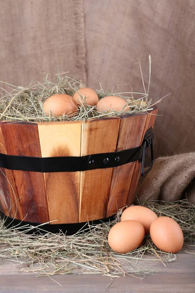 Velký kulatý koš s trávou a čerstvá vejce na vyhození pozadí — Stock fotografie