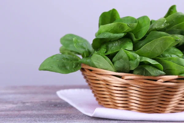 Sorrel fresco in cesto di vimini rotondo su tovagliolo su sfondo di legno — Foto Stock