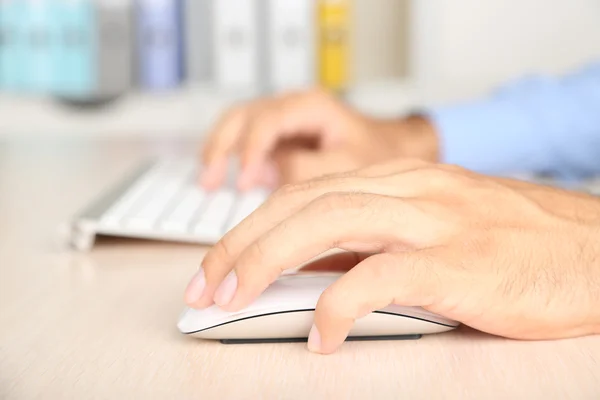 Mann arbeitet mit Tastatur auf Holztisch auf Ordnern Hintergrund Nahaufnahme — Stockfoto