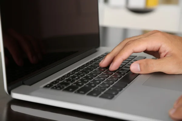 Homem trabalhando no laptop na mesa de madeira no fundo da pasta — Fotografia de Stock