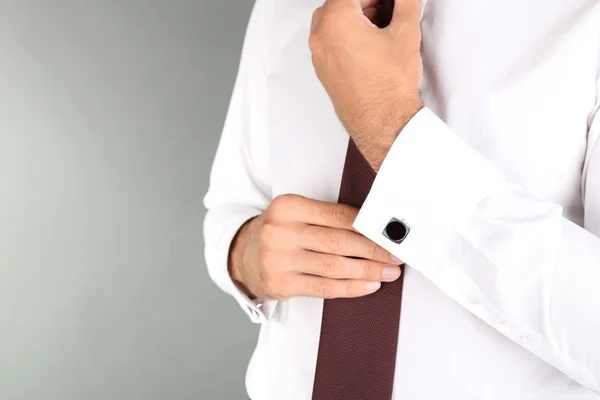 Man doing collar button up on grey background — Stock Photo, Image
