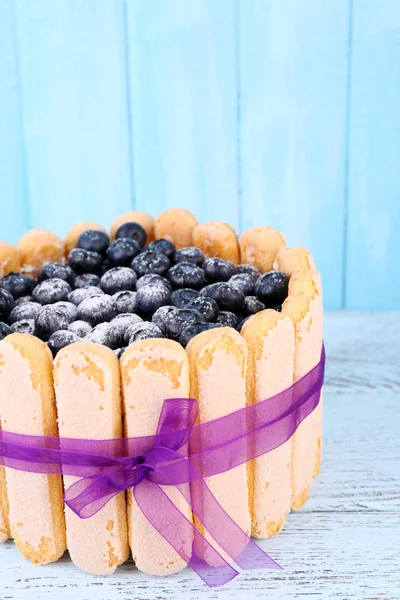 Gâteau savoureux Charlotte aux myrtilles sur table en bois bleu — Photo