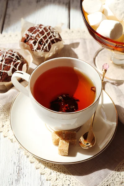 Cup of tea with cupcakes on table, close up — Stock Photo, Image