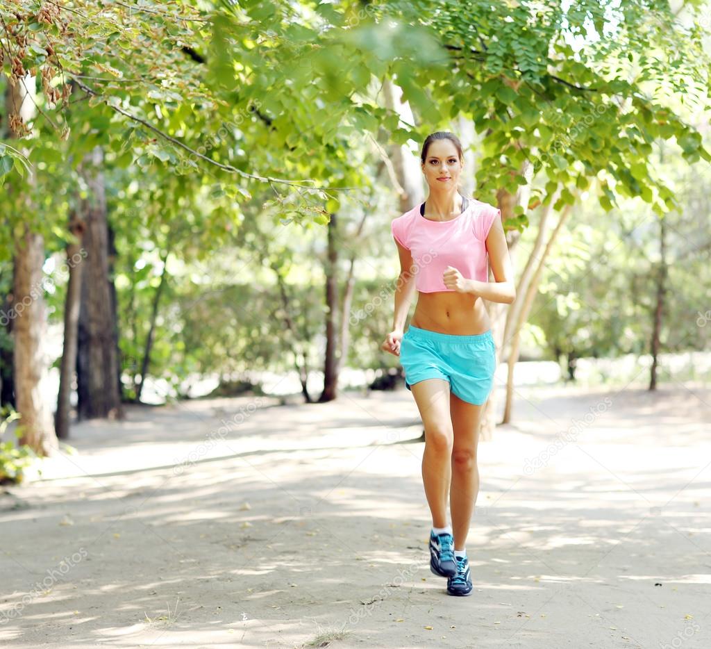 Woman jogging at park Stock Photo by ©belchonock 52340035
