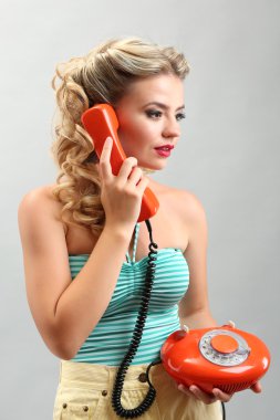 Gri arka plan üzerinde eski telefon ile güzel kız