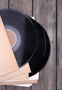 vinil kayıtları ve kağıt kapakları ahşap zemin üzerinde